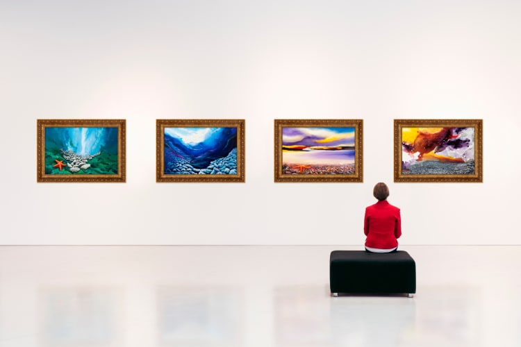 A person sitting looking at art in a gallery