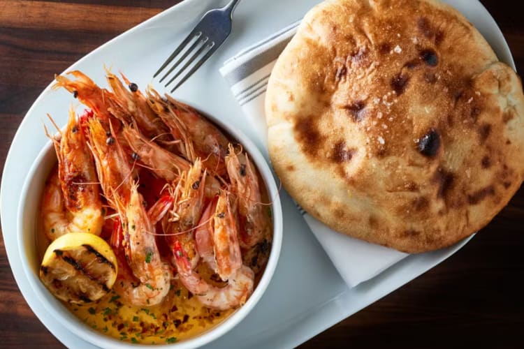 A shrimp dish and bread on a table