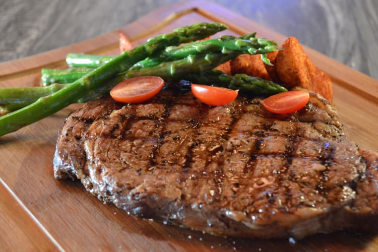 A steak with asparagus and tomatoes