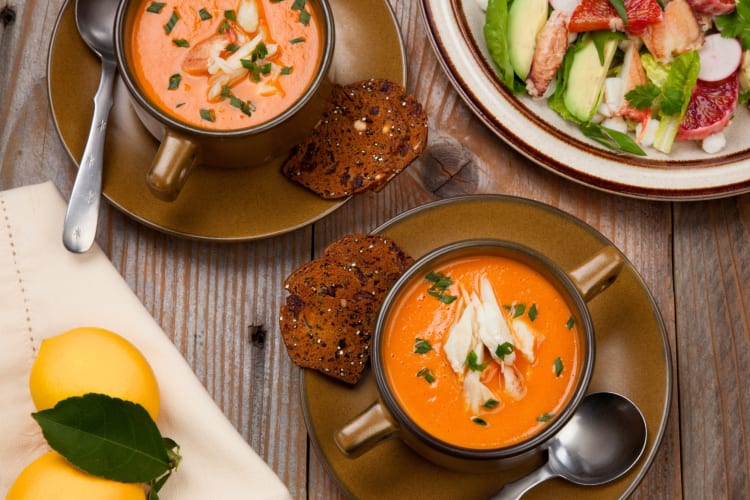 Two bowls of soup with bread