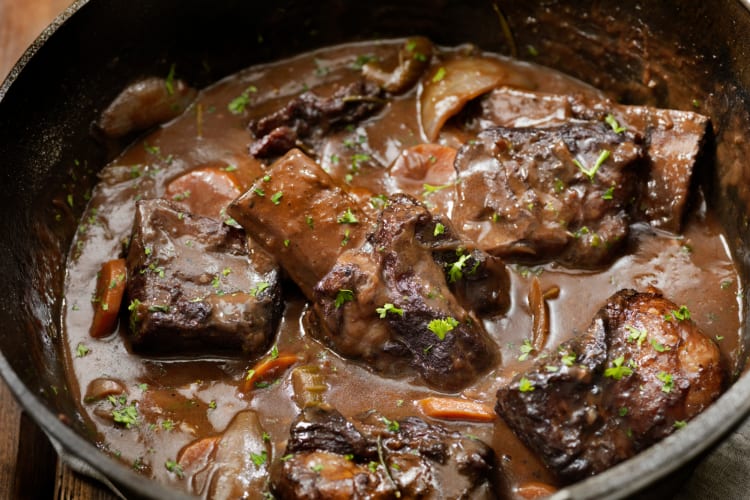 Marinated roasted short rib pieces in a black bowl