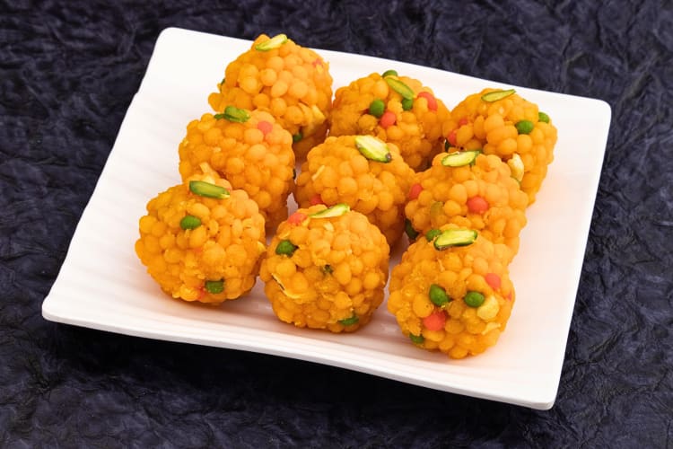 Nine portions of boondi ladoo on a plate