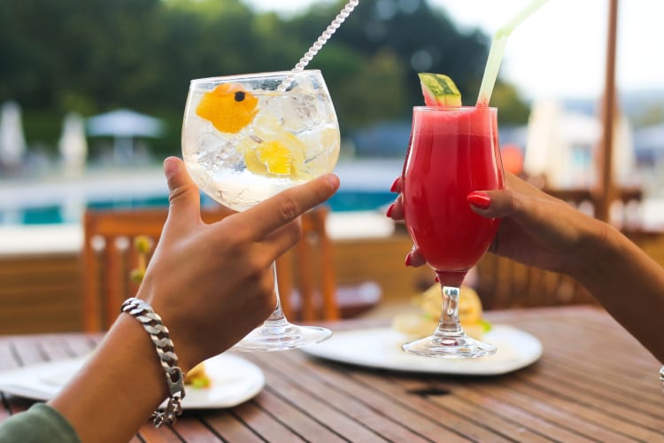 Two people cheersing cocktails