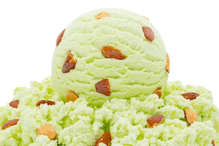 A scoop of pistachio ice cream with almond chunks