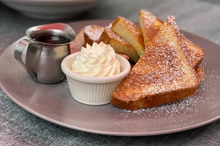 French toast with whipped cream on a plate