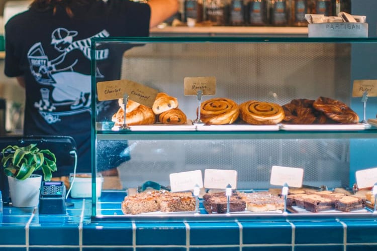 A glass display case with pastries in a coffee shop