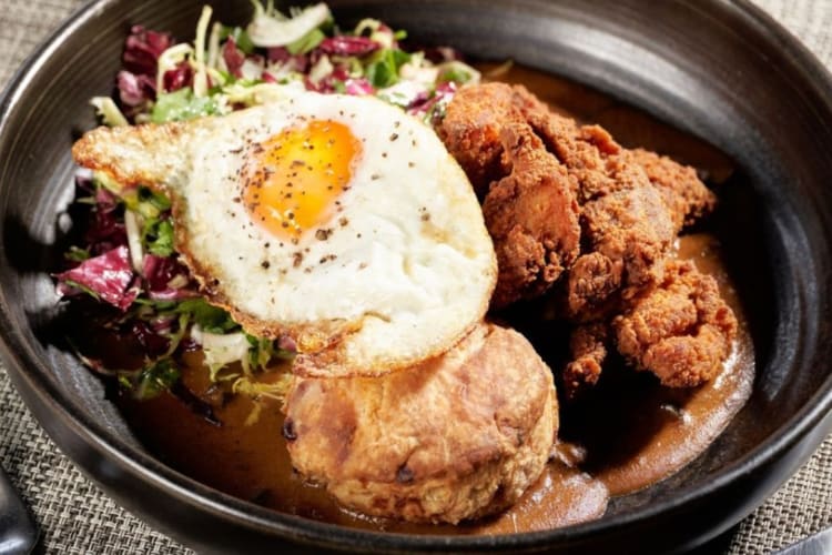 Fried chicken and a goat-cheese biscuit with a fried egg and vegetables