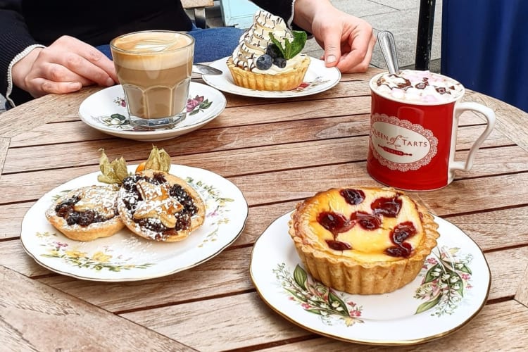 Pastries and hot chocolate on a wooden outdoor table