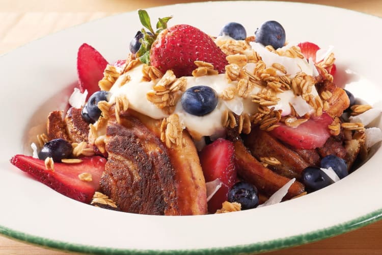 A bowl of brioche French toast with berries, granola and yogurt