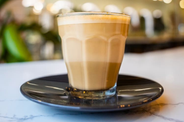 A coffee in a glass cup on a saucer