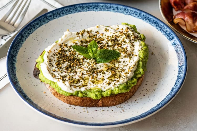 Avocado toast on a white and blue plate