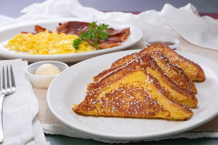 French toast on a table next to other breakfast dishes