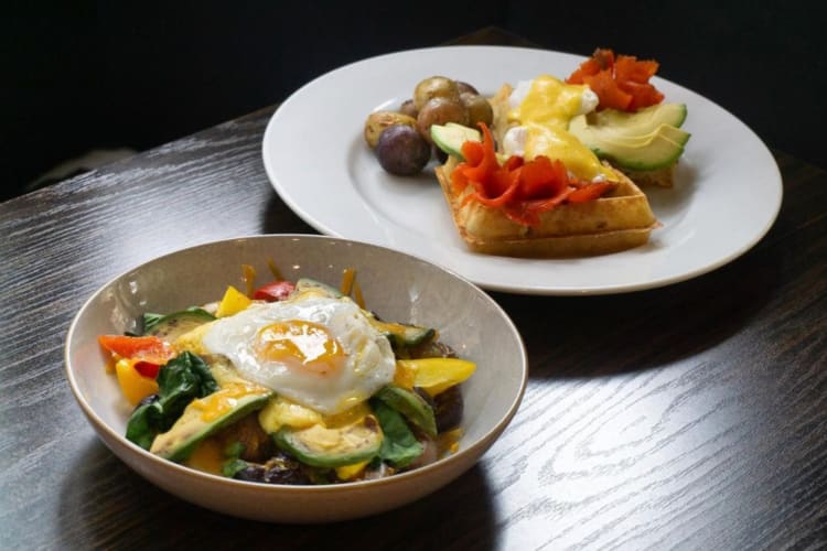 Two breakfast dishes on a dark wood table