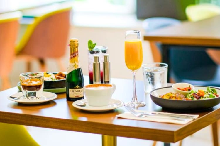 Breakfast dishes, orange juice and champagne on a table