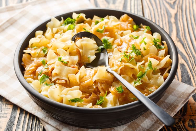 A cabbage and flat noodle dish in a pan