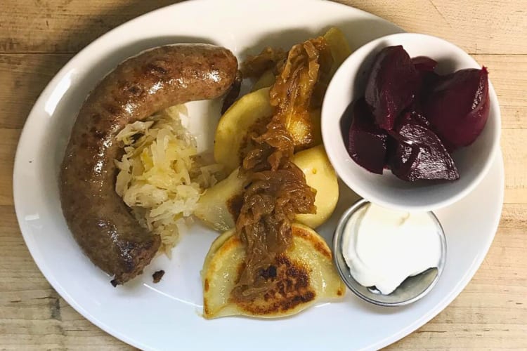 Aerial shot of a sausage, onions, pierogies, beetroot and sauce from Butterjoint
