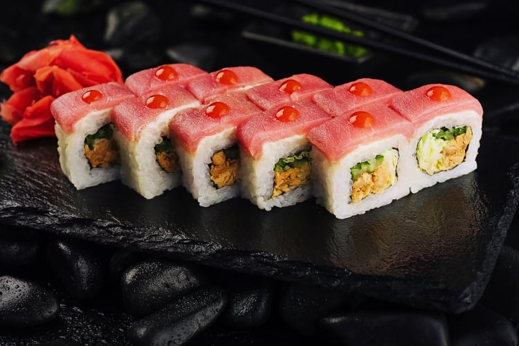 tuna sushi rolls on a black stone board