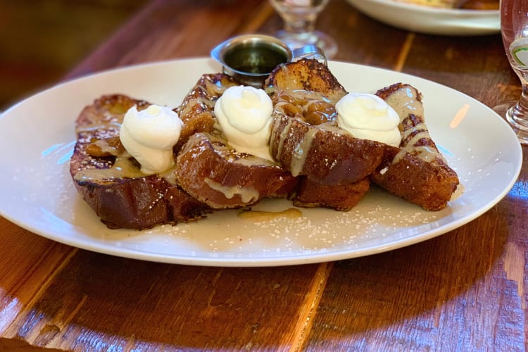 French toast pieces with whipped cream and syrup on top 