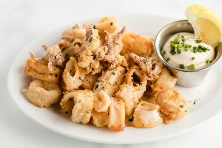 Fried squid with aioli and a slice of lemon.