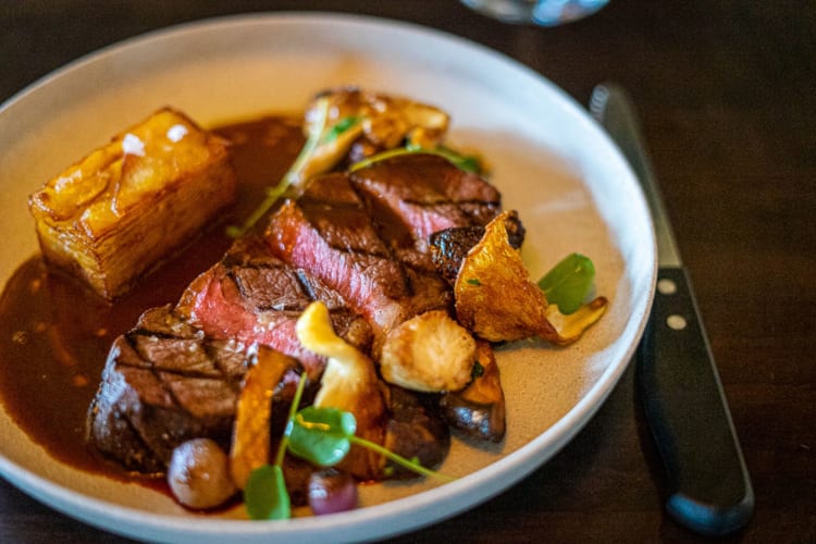 Bison striploin with roasted veggies and jus.