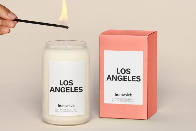 A candle being lit next to a box that says Los Angeles