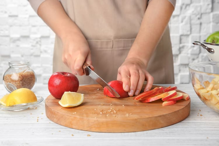 A person cutting apples on a board