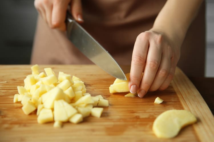 A person cutting apples into cubes