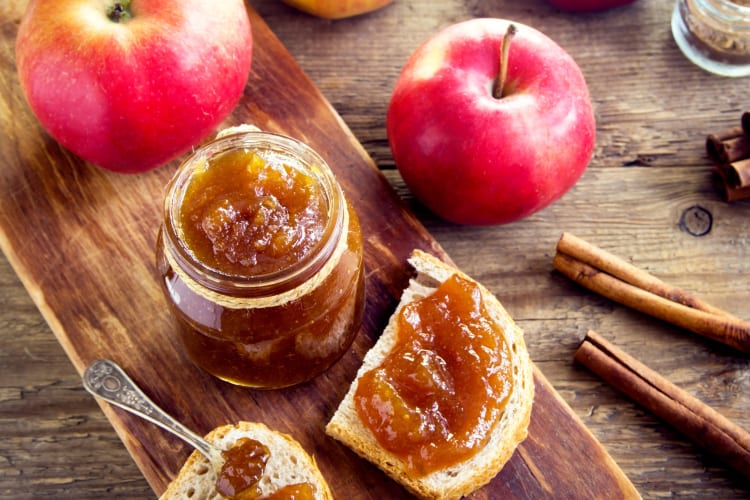 Apple butter on bread next to fresh apples