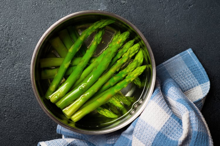 Asparagus in an ice bath next to a cloth