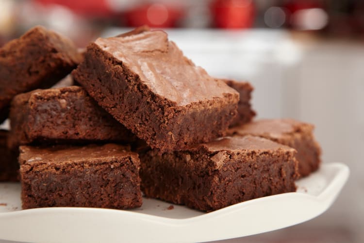 A stack of chocolate brownies on a white plate