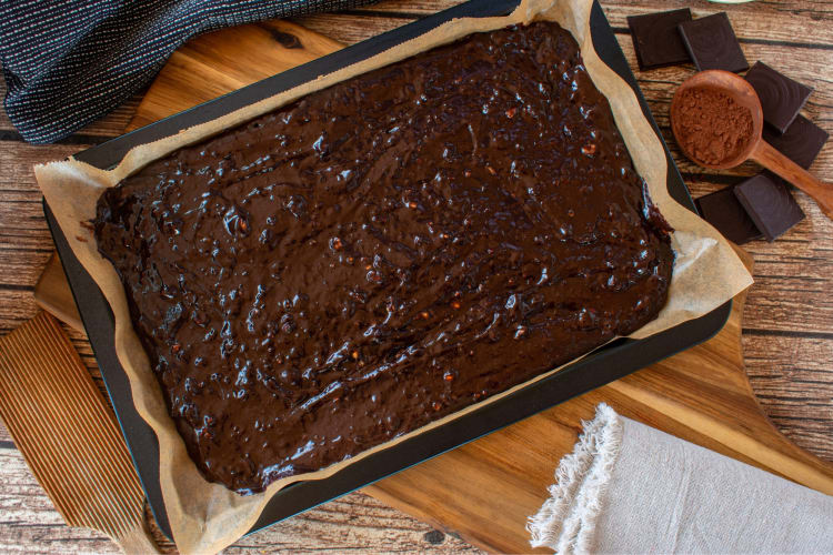 Brownie batter in a tray next to ingredients
