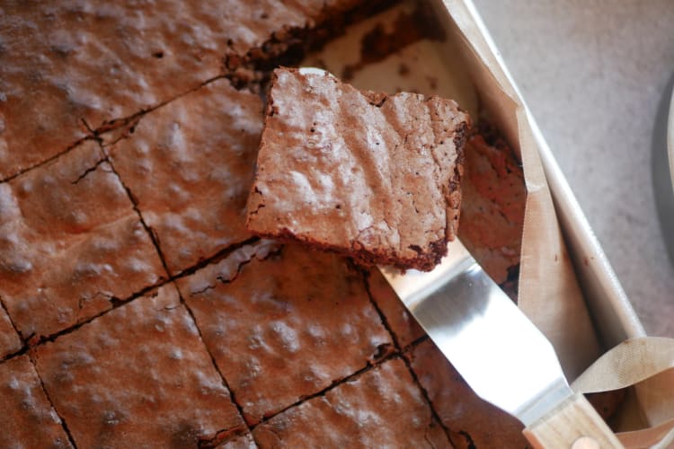 A brownie being taken out of a tray