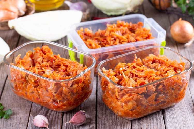 Three plastic containers with cooked cabbage