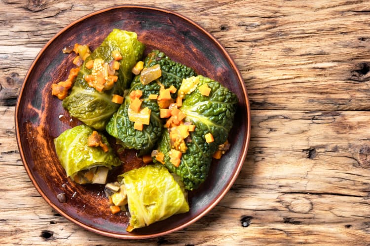 Cabbage rolls on a plate on a wooden surface