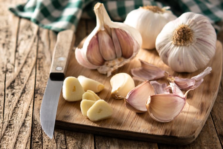 Bulbs of garlic and chopped garlic on a board