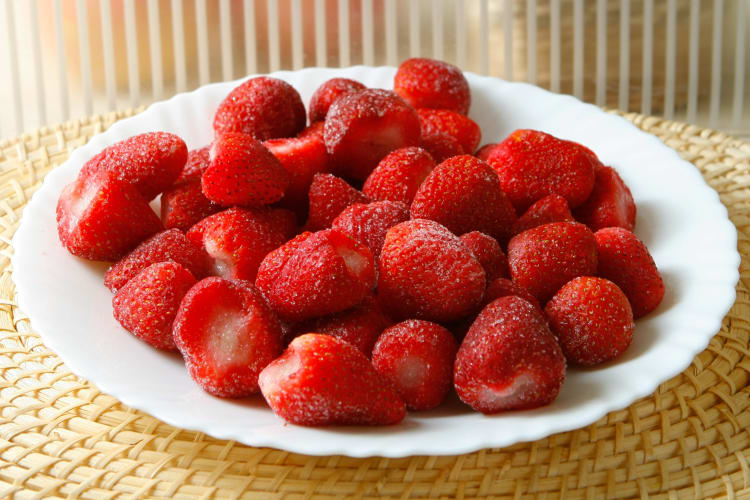 A plate with frozen strawberries on it