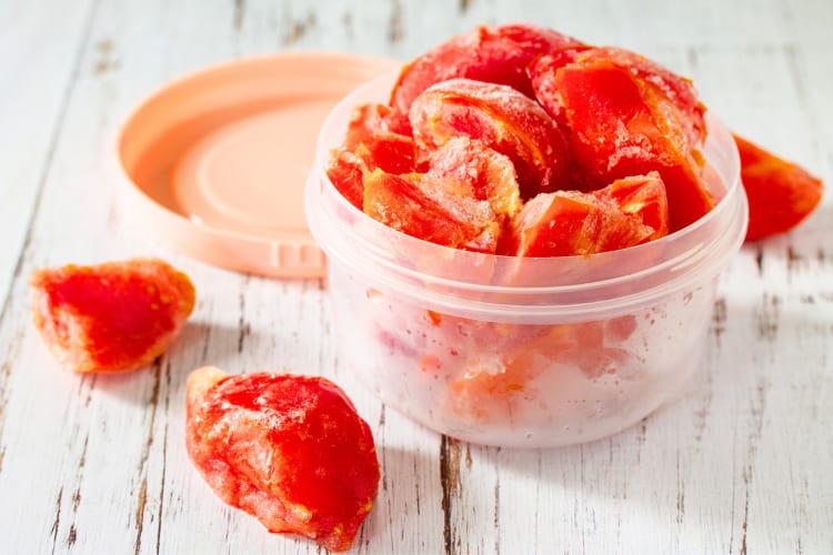 Frozen tomatoes in a tuppaware container