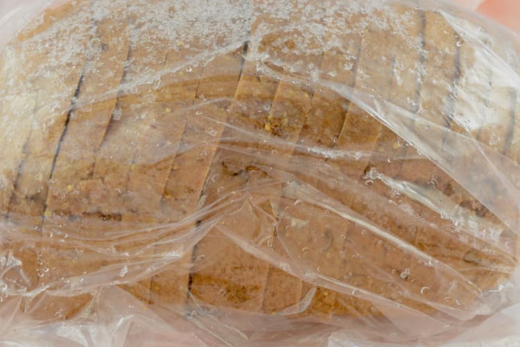 A bag of frozen bread with condensation on the outside.