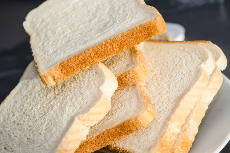 Bread is best thawed at room temperature while it's still wrapped in plastic wrap and foil, to avoid condensation forming on the bread.