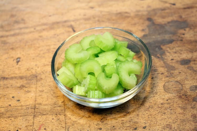 A small glass bowl filled with chopped celery.