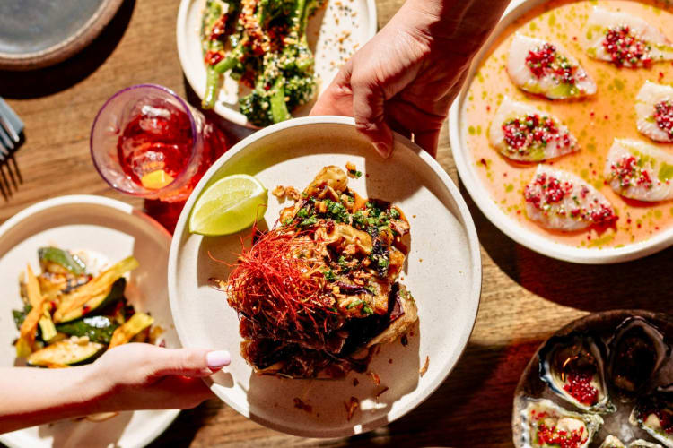 A restaurant table full of sharing plates. 
