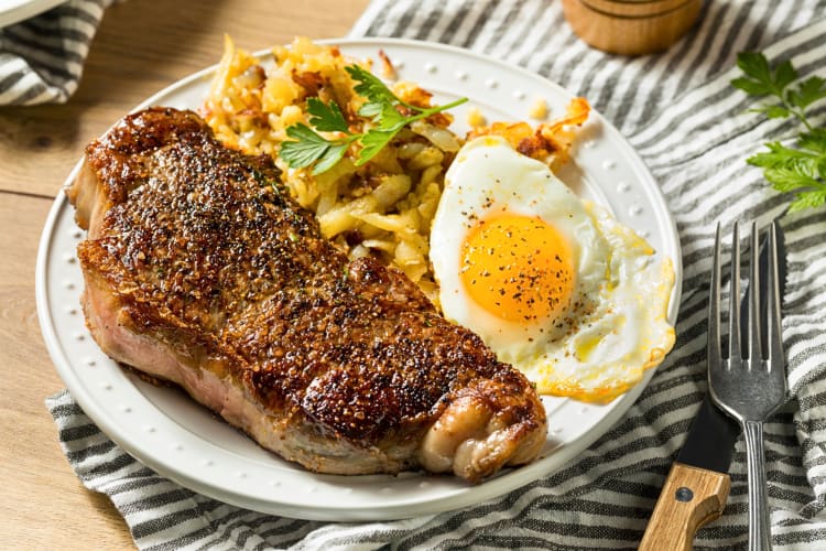 Breakfast meal with an egg, steak and fries