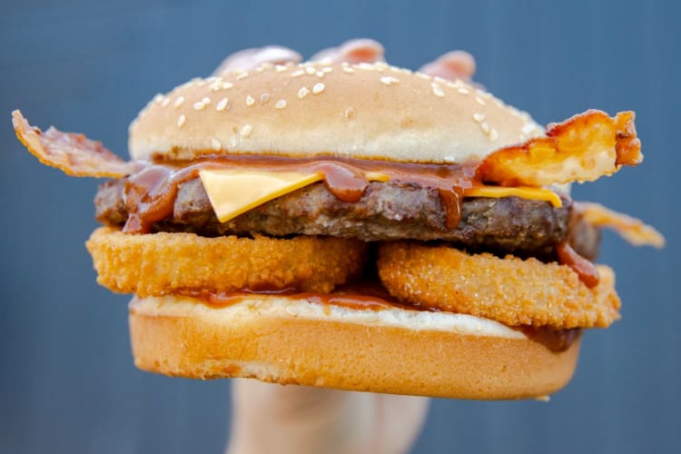 A burger with onion rings and bacon