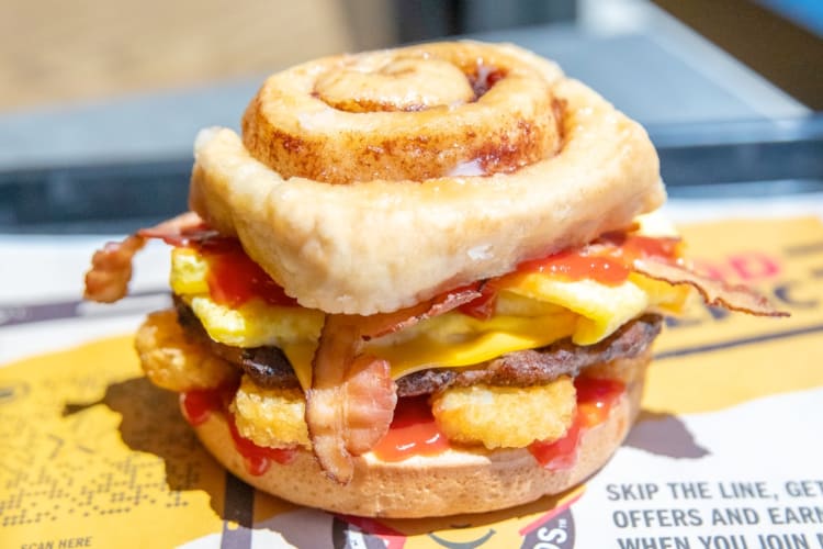 A breakfast sandwich made with cinnamon rolls