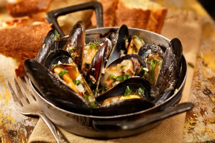 Mussels served in a bowl with a fork next to it