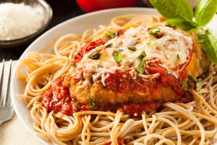 Chicken parmigiana with melted cheese and garnish on top