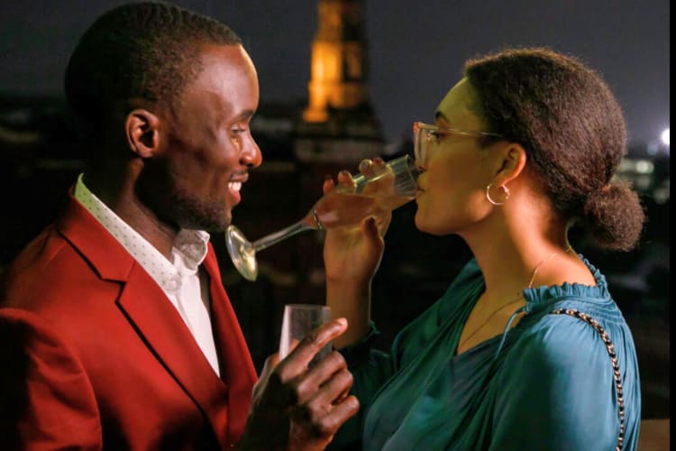 A couple having a glass of champagne on a rooftop at night