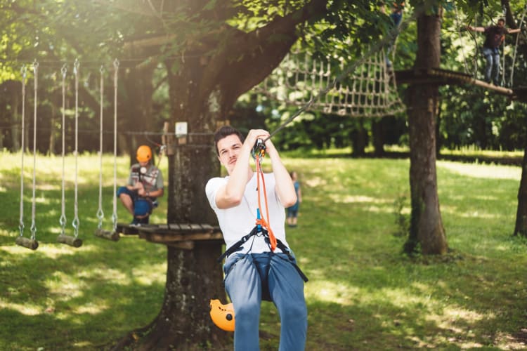 A man ziplining between the trees