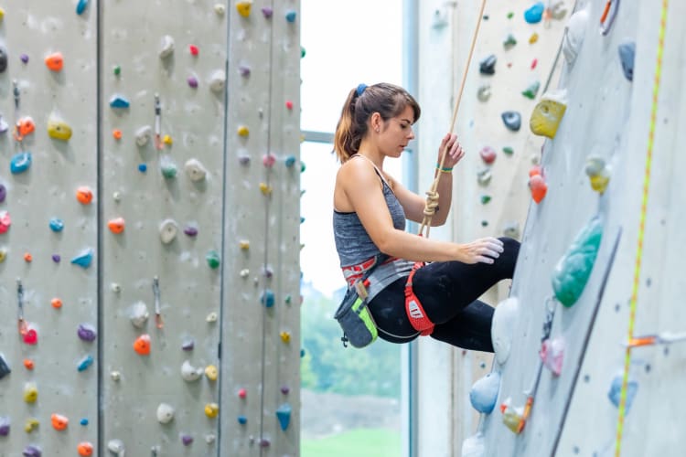 A woman climbing on an indoor rock climbing wall