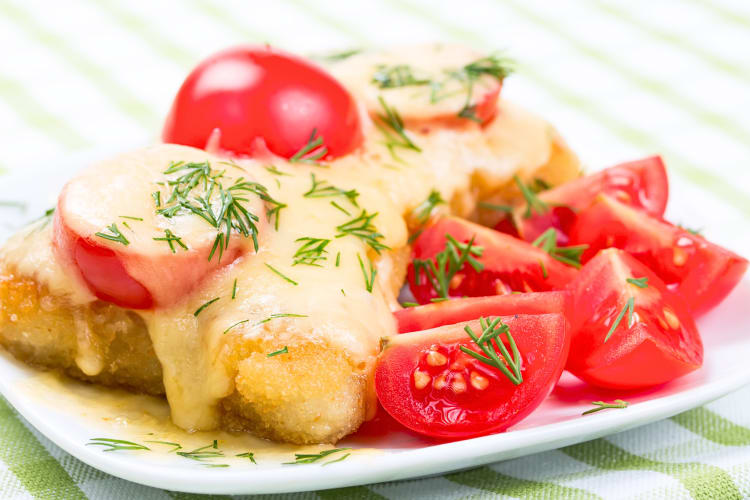 Tomatoes and fried chicken under melted cheese